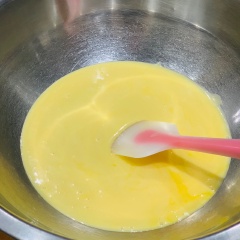 Cho 60ml sữa tươi, 60g dầu bắp và 50g đường bột vào thố sâu lòng, dùng phới lòng khuấy cho hỗn hợp quyện đều và đặc sệt. Tách lấy 5 lòng đỏ trứng gà cho vào thố sữa, khuấy cho trứng tan và hỗn hợp làm bánh được quyện đều. Sau đó rây 80g bột mì vào, dùng spatula khuấy đều.