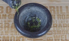 Bắt đầu bằng cách thêm 1 tép tỏi và 1 muỗng canh cuống ngò rí vào cối giã nhuyễn. Sau đó cho 250g gà xay và 250g tôm đã bóc vỏ vào máy xay thực phẩm, xay trong khoảng 30 giây.