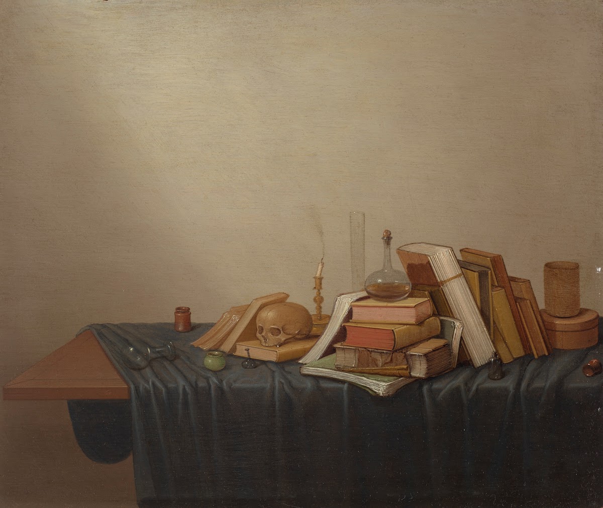 A Vanitas with books a skull a candle and various objects on a table