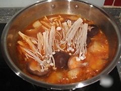 Cho nấm kim chi, nấm đông cô, nấm linh chi trắng vào. Nêm gia vị 1/2 muỗng cà phê muối, 1 muỗng canh đường trắng, 1 muỗng cà phê hạt nêm chay cho vừa ăn, nấu sôi là được.