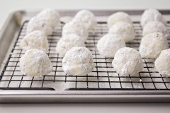 Cách làm bánh cookie snowball giáng sinh: Dùng muỗng múc thành từng viên bột, vo tròn trong tay và đặt lên khay nướng. Bạn cứ làm như vậy đến khi hết nguyên liệu bột. Nhớ chừa khoảng cách giữa các viên bột nha. Đặt khay bánh vào lò nướng tầm 14 - 15 phút đến khi thấy bánh chín, có màu vàng nâu thì lấy ra để nguội 5 phút. Sau đó, phủ lên bánh một lớp đường bột sau cho đường bọc kín hết khắp viên bánh là được nha.