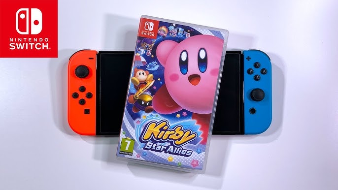 Kirby riding a star vehicle in Kirby Air Riders, with other Kirby characters in the background.