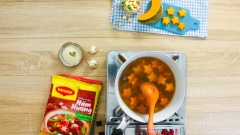 Khi hạt sen và thịt bò gần mềm, cho vào bí đỏ, nêm gia vị với ½ muỗng canh đường và 1 muỗng canh hạt nêm nấm hương Maggi. Khuấy nhẹ canh, sau cùng rắc hành lá cho thơm rồi tắt bếp.