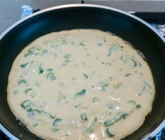 Hành lá băm nhuyễn, cho vào tô trộn cùng với trứng gà, bã đậu nành, sau đó bạn cho bột mì vào đảo đều, rót sữa đậu nành, dầu mè, muối, tiêu vào và tiếp tục đánh tan hỗn hợp. Bắc chảo dầu lên bếp, đổ hỗn hợp vào, tráng đều và chiên 4-5 phút mỗi bên cho đến khi chín vàng.