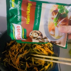 Tiếp đến nêm gia vị Knorr Nấm Hương Chay vào chảo miến xào. Cho thêm thìa mì chính vào chảo, đảo đều lên.
