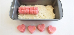 Thoa một lớp bơ chống dính cho khuôn loaf hoặc lót giấy nến. Rắc 1/2 lượng phô mai Parmesan cắt nhỏ vào đáy khuôn, đổ 1 phần bột vào trải đều, xếp bánh trái tim hồng vào giữa, thật sát nhau và đổ phần bột còn lại vào phủ kín trái kín, rắc 1/2 phần phô mai còn lại lên trên. Nướng bánh trong lò khoảng 40 - 45 phút đến khi thấy bánh có màu vàng nâu thì lấy bánh ra khỏi lò để khoảng 5 phút cho nguội bớt rồi lấy ra khỏi khuôn và để nguội 45 phút sau đó mới cắt bánh thành từng lát và thưởng thức.