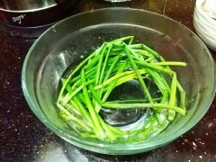 Hành lá cắt bỏ đầu lấy cọng, rửa sạch rồi đem chần sơ qua nước sôi, sau đó chần qua nước lạnh. Ướp tôm với tỏi, hành bằm, 1 muỗng cà phê tiêu, 1 muỗng cà phê đường, để tôm khoảng 15 phút cho thấm gia vị. Lấy từng miếng thịt cho lần lượt tôm, ớt chuông vào cuộn lại. Sau đó lấy hành lá buộc lại, làm như vậy cho đến khi hết tôm và thịt.