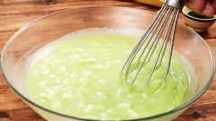 Khuấy đều 150g trứng gà, 20g nước cốt lá dứa, 200g đường cát, 200g bột năng, 4g baking soda, 4g baking powder và hỗn hợp bơ sữa. Sau đó cho cơm dừa vào khuấy đều