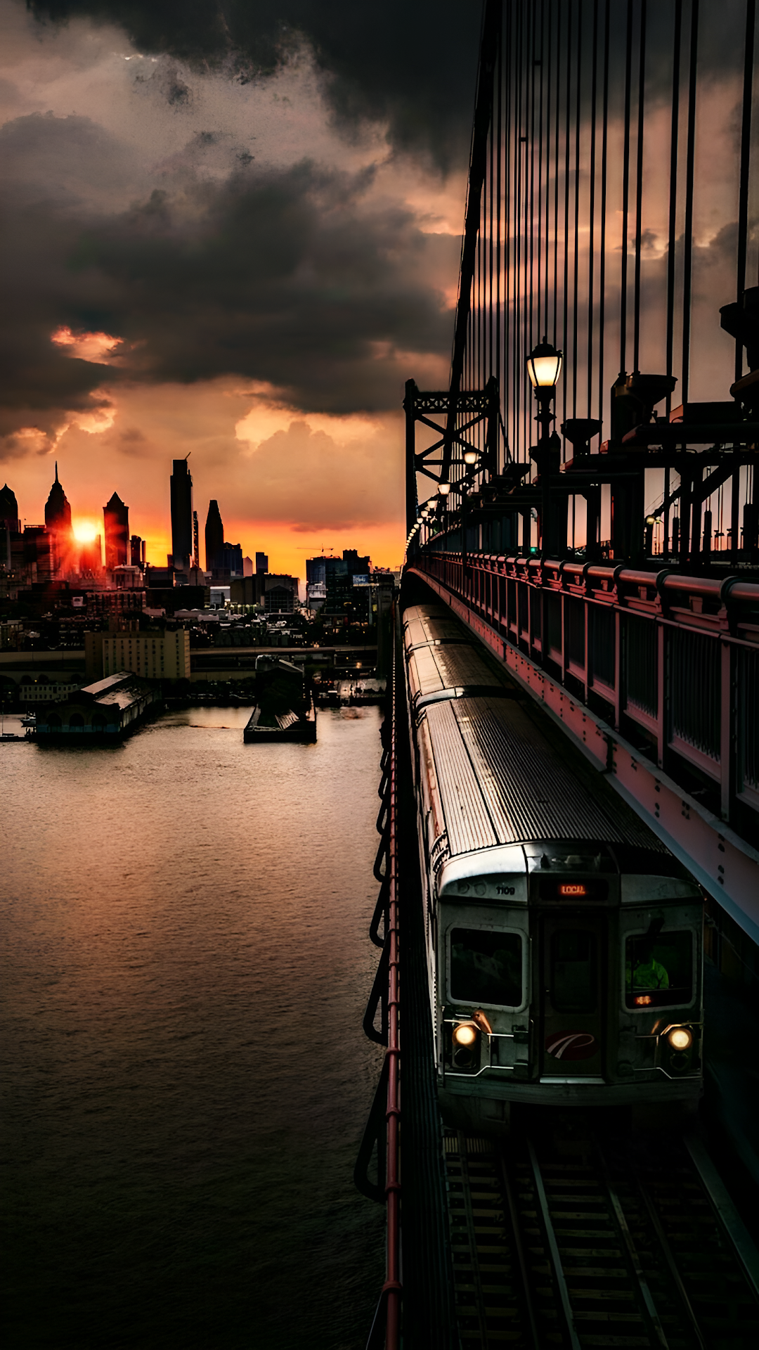 Commuter Train Crossing Bridge at Dramatic Sunset Skyline - Free 4K mobile Wallpaper