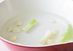 Đầu tiên, cần đun sôi khoảng 1 lít nước với đầu hành trắng, tỏi tép bóc vỏ, ớt trái. Tiếp theo, cắt thịt bò thành từng lát dày cỡ 3cm cho vào nồi nước đun sôi.