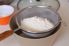 Rây bột mì và bột nở qua khay để loại bỏ vón cục. Trong 1 thố sạch, Đánh bơ và đường cho có màu vàng nhạt. Sau đó cho bột vừa ray vào, trộn cho quyện đều. Sau đó cho vào túi bóp kem.