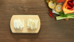 Gấc bỏ vỏ, hạt, lấy 100gr thịt gấc cho vào tô, thêm 2 muỗng canh rượu trắng, khuấy đều và dầm nhuyễn cho gấc lên màu đẹp. Cắt sợi 100gr nấm đùi gà, cắt đôi và bỏ gốc 100gr nấm kim châm.