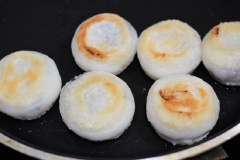Dùng lòng bàn tay ấn dẹt chiếc bánh xuống. Đặt chảo lên bếp, cho dầu vào chảo, đun nóng dầu, cho bánh vào chiên nhỏ lửa, khoảng 4 - 5 phút là bánh chín.