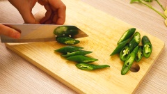 Thái ớt xanh thành những miếng xéo vừa ăn. Ớt chuông đỏ cắt miếng dài.