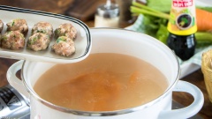 Bắc nồi nước hầm xương lên bếp, thêm cà rốt vào rồi nấu lên. Nước sôi bạn thả thịt viên vào nấu chín, hớt bỏ bọt bẩn để nước canh được trong hơn. Khi nước sôi lại thì bạn nêm vào canh 1/2 muỗng canh hạt nêm để món canh có vị vừa ăn. Sau đó bạn cho lần lượt cải bẹ xanh, nấm rơm và gừng vào nồi. Nấu đến khi nước sôi lại lần nữa thì tắt bếp.