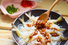 Xếp bún gạo đã ngâm mềm lên dĩa rồi xếp tôm lên trên. Tiếp theo rưới nước sốt tỏi lên từng con tôm và 1 ít ra phần bún gạo. Cuối cùng rãi đều ớt chuông ra xung quanh.