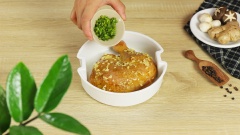 Tiếp theo gắp đùi gà đã ướp vào xửng hấp, rắc thêm 4 rễ rau mùi băm nhuyễn, 5 tép tỏi băm nhuyễn rồi xoa đều khắp đùi gà. Gắp xen kẻ 7 cái nấm hương vào xửng hấp, cho thêm 5 lát gừng tươi rồi đem gà đi hấp thôi.