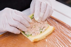 Tiếp tục cuộn lại để hoàn thiện. Mỗi cuộn bánh mì lại cắt làm đôi và xếp xen kẽ nhau lên trên đĩa chữ nhật dài.