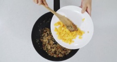 Tiếp đến cho cơm trắng vào, trộn đều. Cuối cùng cho trứng chiên vào, đảo đều và chiên cho hạt cơm chín khô như ý là được.
