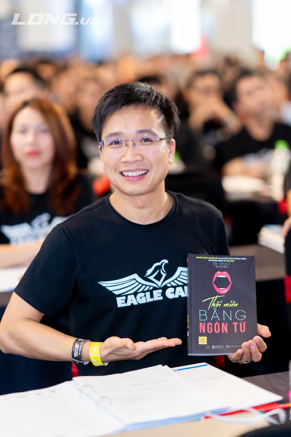 Anh Taka tại Eagle Camp cầm cuốn sách Thôi miên bằng ngôn từ, bước ngoặt trên hành trình trở thành diễn giả trực tuyến