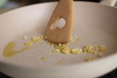 Xào Tteok: Cho 1 muỗng canh dầu ăn vào chảo lớn (trong hình là mình sử dụng dầu Olive, các bạn vẫn có thể sử dụng dầu ăn bình thường nhé), đợi dầu nóng rồi cho số tỏi băm còn lại vào phi vàng. Khi tỏi đã vàng đều và dậy mùi thơm thì cho Tteok vào chảo, đảo đều tay khoảng 3 – 4 phút (Lưu ý: mình KHÔNG để cho Tteok bị giòn nhé).