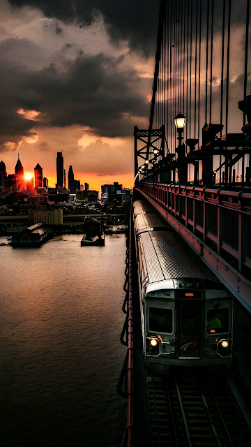 Train Crossing Suspension Bridge Dramatic Sunset Skyline