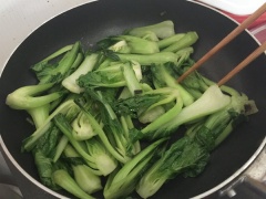 Tiếp đến cho tấc cả cải thìa vào chảo. Xào cải với lửa lớn. Dùng đũa đảo liên tục.