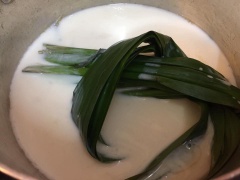 Đổ sữa tươi vào nồi, vò lá dứa cho vào đun cùng, cho đường vào khuấy đều cho tan đường. Hoà 30g bột năng còn lại với chút nước. Khi sữa sôi, từ từ đổ phần bột năng vào vừa đổ vừa khuấy đều để được hỗn hợp nước cốt dừa sánh. Tiếp đến bạn cho thêm nước cốt dừa.
