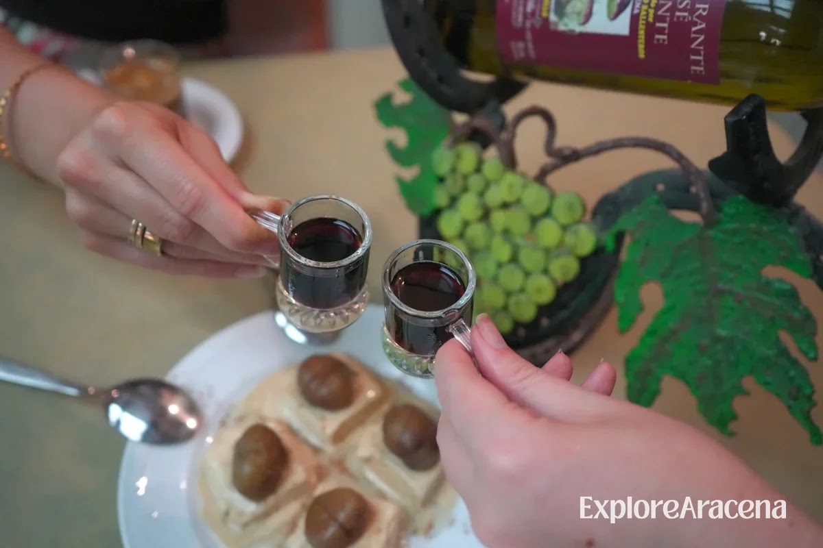 Dessert topped with seasonal walnuts beside miniature mug-shaped glasses filled with a sweet after-dinner drink.