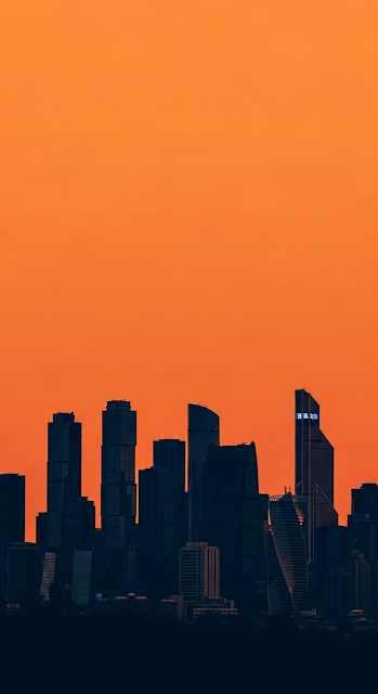 High-Contrast Graphic Silhouette of a Modern City Skyline Against a Vast Monochromatic Orange Sky - Free mobile Wallpaper