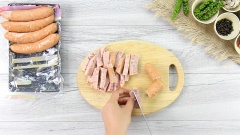 Chuẩn bị nguyên liệu. Xúc xích cắt làm 3, sau đó tiếp tục cắt làm 4 để có những thanh xúc xích dài. Hành tím và tỏi lột vỏ, băm nhuyễn. Tiêu hột đen giã nhuyễn hoặc dùng dạng tiêu xay. Tiêu xanh lấy 2 nhánh đem tách hạt, giã hơi dập, 4 nhánh còn lại để riêng. Ớt lấy 3 trái đem băm nhuyễn, 5 trái còn laị để riêng.