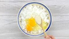 Chuẩn bị 200gr cơm nguội, đập vào cơm 2 quả trứng gà, nêm 1 muỗng canh hạt nêm, 1/3 muỗng canh tiêu, mang bao tay bóp đều cho trứng và gia vị áo đều vào cơm.