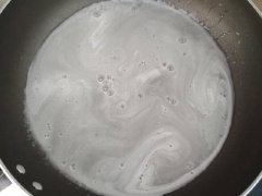 Cho nước dừa + đường vào chảo đun sôi với lửa vừa, sau đó hạ lửa nhỏ đun cho nước đường hơi sánh lại. Đổ tô đậu phộng rang vàng vào đảo đều tay cho đậu phộng bám đều hỗn hợp đường.