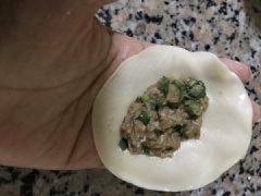 Múc 1 muỗng nhân thịt bò vào vỏ bánh rồi tiến hành gấp thành hình những chiếc sủi cảo có hình dạng như chiếc thuyền nhỏ. Làm tương tự cho hết nguyên liệu.