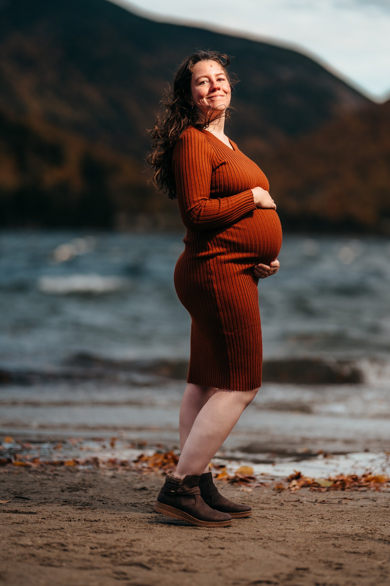 Holly alone on the shore, hands on her bump