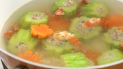 Đun sôi 1.2 lít nước, sau đó nhẹ nhàng thả từng khoanh khổ qua tôm xòe vào nồi, cho thêm 80gr cà rốt cắt lát tỉa hoa vào rồi nấu thêm 20 phút. Khi khổ qua và cà rốt chín mềm thì nêm vào 1 muỗng canh Bột nêm tự nhiên vị gà Knorr, khuấy đều rồi tắt bếp.