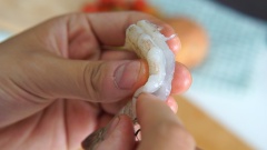 Bóc vỏ 300gr tôm tươi, bỏ đầu, giữ lại đuôi tôm, để tôm cuộn khoai tây chiên lên thì đuôi tôm sẽ xòe ra trông đẹp mắt hơn. Xẻ phần lưng để lấy chỉ tôm, khía phần trong của tôm để khi chiên tôm không bị cong lại. Ướp tôm với một ít muối và tiêu.