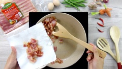 Bắc chảo lên bếp, đợi chảo nóng thì cho thịt xông khói vào chiên cho ra bớt mỡ, thịt hơi xém vàng thì vớt ra cho vào dĩa có lót giấy thấm bớt dầu.