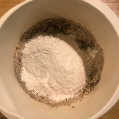 Cho bột trà xanh vào âu. Chia bột mì thành 2- 3 phần, cho từng phần vào âu, trộn đều. Nên dùng âu thành cao và trộn bằng phới trước rồi mới dùng máy đánh cho đều, tránh cho bột bay và bắn ra ngoài. Cho chocolate chip trắng vào trộn đều lại lần nữa.