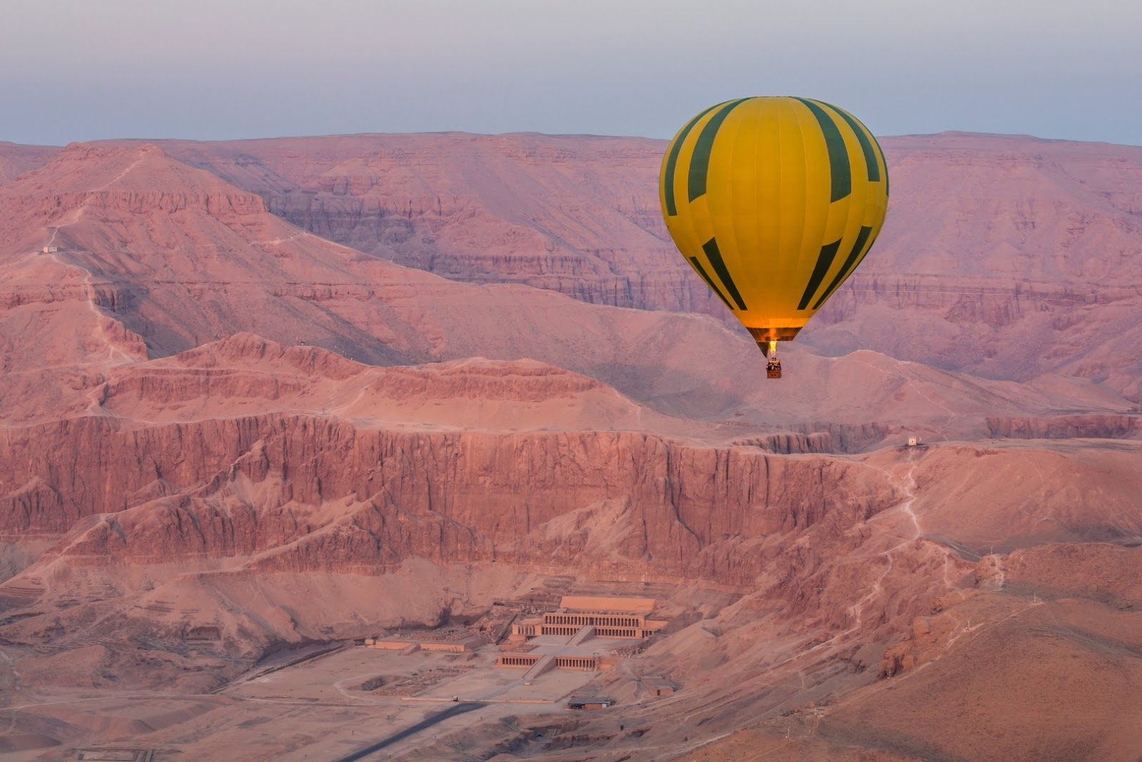 Hot-air balloon flying above the Nile Valley and desert landscape near Luxor, Egypt.