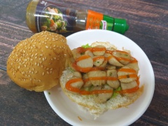 Cắt đôi bánh burger, xếp xà lách và cà chua cắt lát lên trên, sau đó cho cá viên đã xào lên trên, thêm ít tương ớt hoặc tương cà, kẹp bánh lại là thưởng thức được rồi đó.