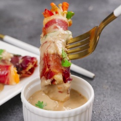 Đặt các cuộn dăm bông serrano lên đĩa và rưới nước sốt mè lên trên. Có thể thưởng thức với cơm. Khi thưởng thức bạn sẽ cảm nhận được hương vị đậm đà của cuộn dăm bông serrano, vị ngọt tự nhiên của nấm kim châm, ớt chuông, cà rốt rốt, vị béo và thơm của nước sốt mè rang, sẽ khiến cho bạn càng ăn càng si mê và nồi cơm sẽ "bay" sạch trong tích tắc.
