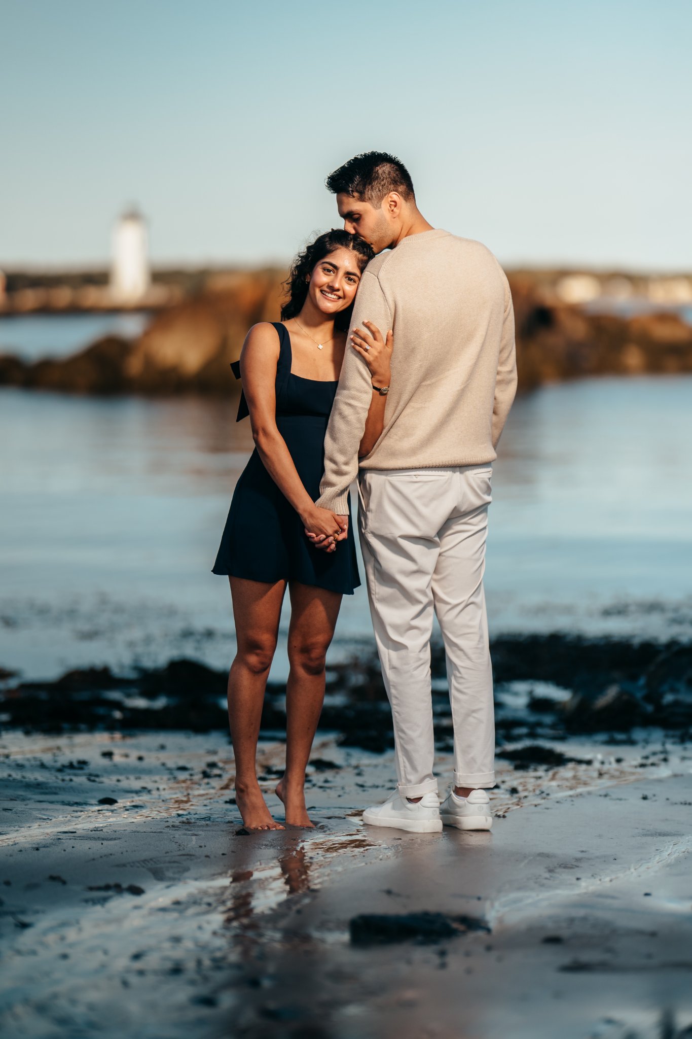 Sumeet kissing Jasmine's forehead with the lighthouse behind them