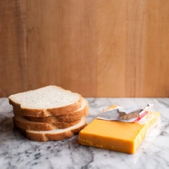 Chuẩn bị bánh mì và phô mai. Bào sợi phô mai.