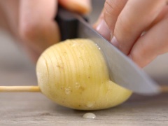 Làm nóng lò ở 200 độ C. Rửa sạch và để ráo hương thảo, cắt nhỏ; Khoai tây và khoai tây tím rửa sạch, để ráo nước. Xuyên một cây đũa tre ngang qua củ khoai tây. Lưu ý, xuyên cây tre ở vị trí 1/4 phía dưới của củ khoai. Dùng dao khứa củ khoai thành lát mỏng nhưng chỉ cắt đến khi gần chạm cây tre, không cắt đứt hẳn.