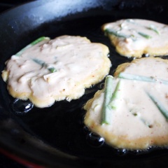 Tiếp đó cho hành lá, kimchi cắt khúc vào tô bột và trộn đều. Làm nóng chảo với dầu ăn, dùng muỗng múc bột cho vào chảo tạo thành hình tròn, tùy kích thước chảo mà cho từ 2 - 4 bánh vào chiên nha. Bạn chiên mỗi mặt như vậy là 5 phút cho chín vàng đều rồi lật mặt bánh lại nha. Khi bánh đã chín thì rể ra rank cho ráo bớt dầu.