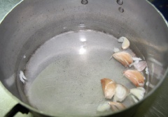 Vớt tai heo vừa chần ra, để ráo nước và cho bớt nóng rồi cạo sạch lông một lần nữa. Rửa tai heo vừa chần bằng nước lạnh cho sạch. Cho tai heo vào nồi khác, đổ nước vào và luộc chín rồi vớt ra cho ráo. Chế 2 muỗng giấm táo, 1 muỗng đường trắng, tỏi đập dập và 1 lít nước sôi vào nồi. Bắc nồi lên bếp, nấu sôi và khuấy cho tất cả hòa tan với nhau. Tắt bếp, để hỗn hợp giấm đường nguội hẳn.