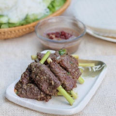 Khi dùng, xếp bánh tráng ra đĩa, bên trên đặt một nhánh cải, xếp vài lát dưa leo, húng quế, bún và một lát thịt bò nướng, cuộn tròn lại, chấm kèm với mắm nêm.
