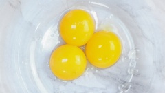 Làm sốt Hollandaise: Khéo léo tách lấy lòng đỏ trứng gà rồi cho 3 lòng đỏ trứng vào tô. Cho thêm 1/2 muỗng cà phê giấm và khuấy đều.