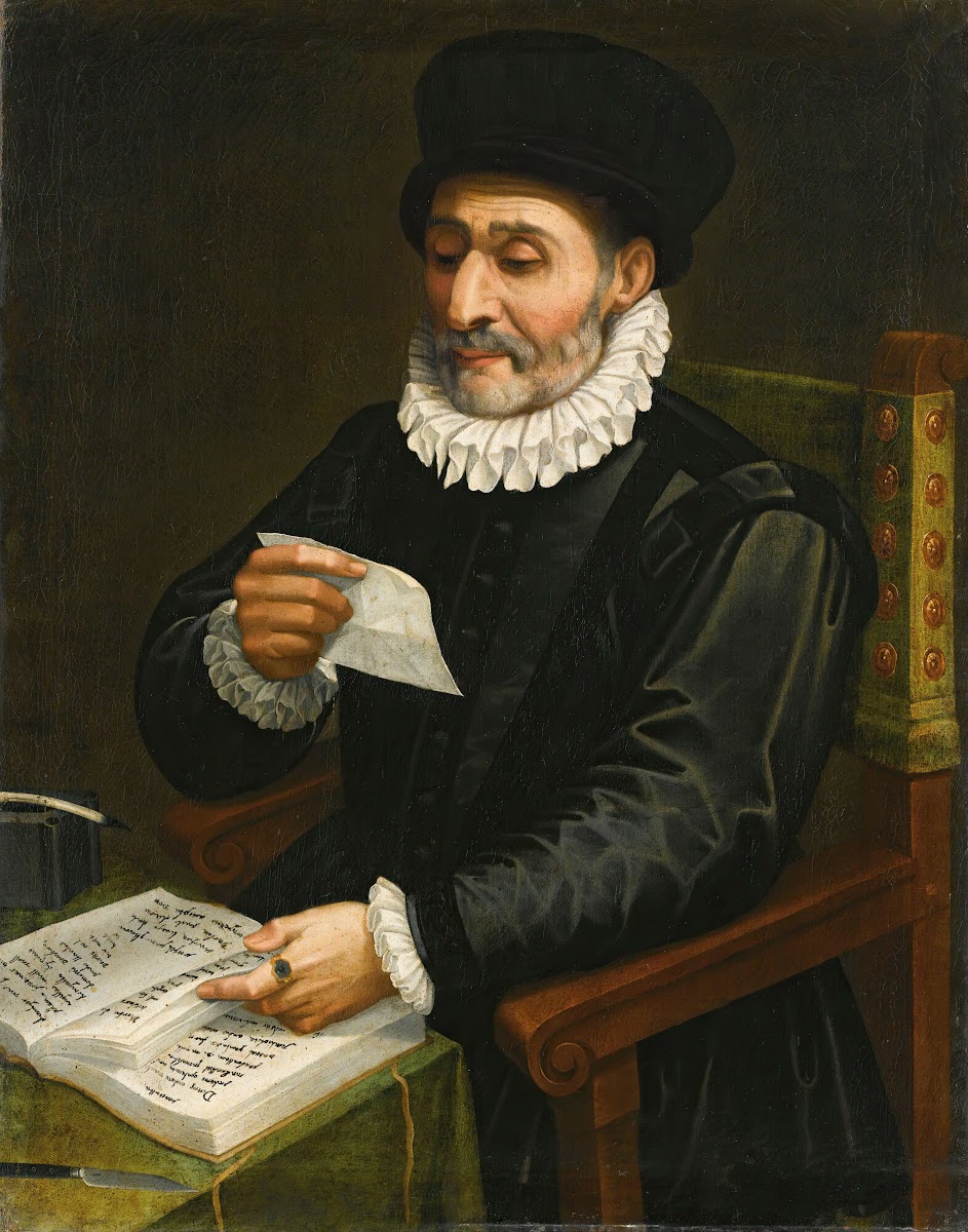 Portrait Of A Man Seated At A Table With An Open Book Reading A Letter